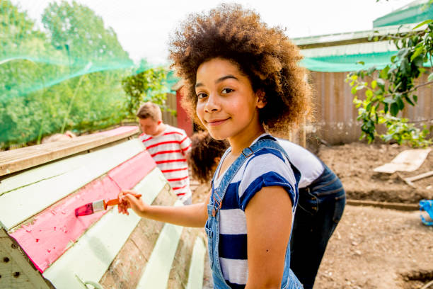 student painting a fence