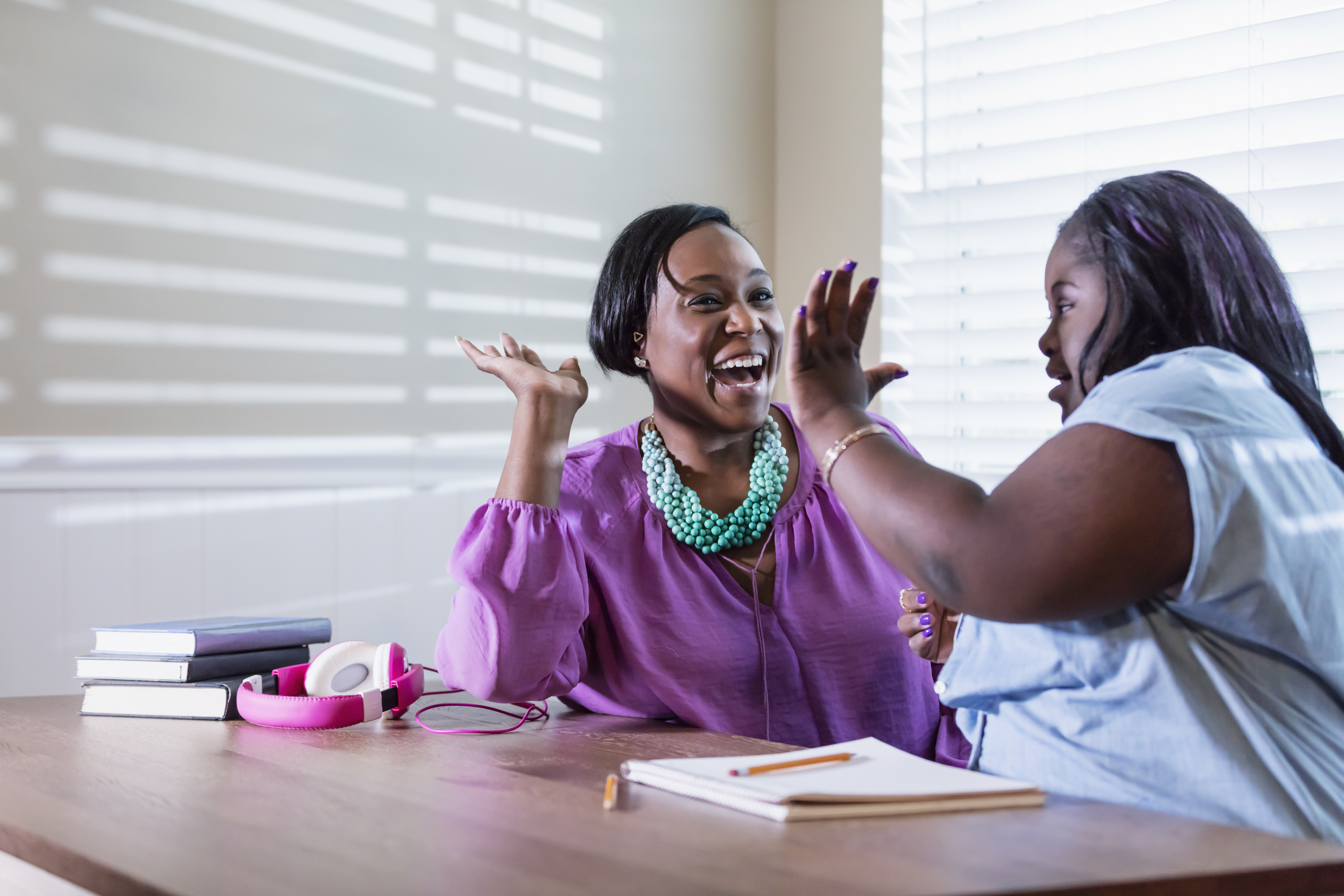 photo of mother and daughter high-fiving